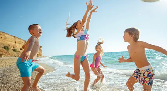 Kids-playing-on-beach-in-swimsuits